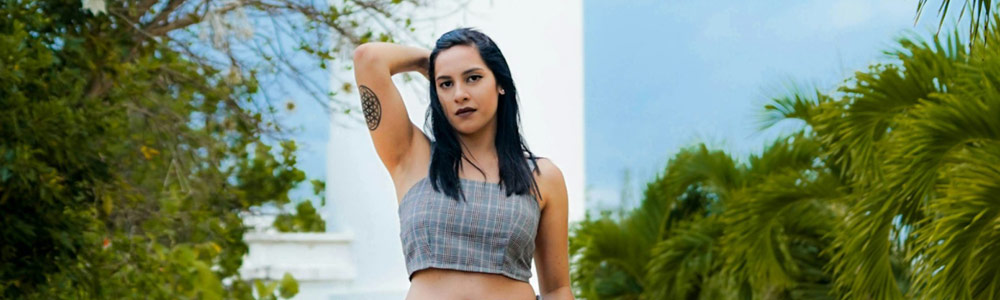 Young woman posing outside with one hand in pocket and other holding back of her head